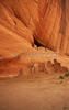 White house ruin below in Canyon de Chelly. White house was built  by ancient Puebloan people and occupied around 1000 years ago.  It is named for the long wall in the upper dwelling that is covered with white plaster. Canyon de Chelly National Monument is located near Chinle, AZ, USA and is hiding numerous house ruins of Navajo Indians, which were settled in Canyon de Chelly. Labyrinth called Canyon de Chelly is really several canyons, which include Canyon de Chelly and Canyon del Muerto. At the mouth of the canyon the rock walls are only 30 feet high. Deeper into the canyons, to the east, the walls rise dramatically until they reach more than 1000 feet above the floor. The cliffs rise straight up, overshadowing the streams, cottonwoods, and small farms below. It has taken about two million years and volumes of water to etch these stone paths through the layers of sandstone and igneous rock as the Defiance Plateau pushed its way upward. Today the canyon still beckons us with its towering stone monoliths and ledges bearing the open windows of ancient people.

