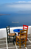 Chairs and table on the roof of traditional Santorini house in village of Firostefani, Santorini, Greece. Traditional Greek houses in Firostefani, Santorini, Greece, are scattered on caldera on Santorini island. White houses with bright blue elements like roofs, windows, doors or fences on dark, almost black rocks of vulcano island Santorini, are trademark of Santorini, known worldwide.
