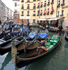 People are enjoying moments on canals of Venice, Italy, traveling around with gondolas. The gondola is a traditional, flat-bottomed Venetian rowing boat, well suited to the conditions of the Venetian lagoon. For centuries gondolas were the chief means of transportation and most common watercraft within Venice. In modern times the iconic boats still have a role in public transport in the city, serving as traghetti (ferries) over the Grand Canal.
