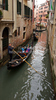 People are enjoying moments on canals of Venice, Italy, traveling around with gondolas. The gondola is a traditional, flat-bottomed Venetian rowing boat, well suited to the conditions of the Venetian lagoon. For centuries gondolas were the chief means of transportation and most common watercraft within Venice. In modern times the iconic boats still have a role in public transport in the city, serving as traghetti (ferries) over the Grand Canal.
