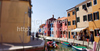 Burano is an island in the Venetian Lagoon, Italy. Like Venice itself, it could more correctly be called an archipelago of four islands linked by bridges. It is situated near Torcello at the northern end of the Lagoon, and is known for its lacework and brightly colored homes. <br> Small, brightly-painted houses on Burano follow a specific system originating from the golden age of its development. If someone wishes to paint their home, one must send a request to the government, who will respond by making notice of the certain colors permitted for that lot.

