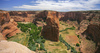 Labyrinth called Canyon de Chelly is really several canyons, which include Canyon de Chelly and Canyon del Muerto. At the mouth of the canyon the rock walls are only 30 feet high. Deeper into the canyons, to the east, the walls rise dramatically until they reach more than 1000 feet above the floor. The cliffs rise straight up, overshadowing the streams, cottonwoods, and small farms below. It has taken about two million years and volumes of water to etch these stone paths through the layers of sandstone and igneous rock as the Defiance Plateau pushed its way upward. Today the canyon still beckons us with its towering stone monoliths and ledges bearing the open windows of ancient people.