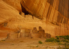 White house ruin below in Canyon de Chelly. White house was built  by ancient Puebloan people and occupied around 1000 years ago.  It is named for the long wall in the upper dwelling that is covered with white plaster. Canyon de Chelly National Monument is located near Chinle, AZ, USA and is hiding numerous house ruins of Navajo Indians, which were settled in Canyon de Chelly. Labyrinth called Canyon de Chelly is really several canyons, which include Canyon de Chelly and Canyon del Muerto. At the mouth of the canyon the rock walls are only 30 feet high. Deeper into the canyons, to the east, the walls rise dramatically until they reach more than 1000 feet above the floor. The cliffs rise straight up, overshadowing the streams, cottonwoods, and small farms below. It has taken about two million years and volumes of water to etch these stone paths through the layers of sandstone and igneous rock as the Defiance Plateau pushed its way upward. Today the canyon still beckons us with its towering stone monoliths and ledges bearing the open windows of ancient people.