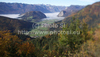 Forest in autumn colors is rising above valley of Bohinj, Slovenia, which is still covered with thick morning fog. View over the valley from Vodnikov razglednik near village Koprivnik, Slovenia, is outstanding and it takes breath away on such sunny morning.

