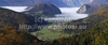 Forest in autumn colors is rising above valley of Bohinj, Slovenia, which is still covered with thick morning fog. View over the valley from Vodnikov razglednik near village Koprivnik, Slovenia, is outstanding and it takes breath away on such sunny morning.
