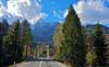 Bridge leading over Sava river near village of Martuljek, Slovenia, on sunny autumn day. In background is north wall of Spik mountain covered with early snow.
