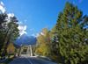 Bridge leading over Sava river near village of Martuljek, Slovenia, on sunny autumn day. In background is north wall of Spik mountain covered with early snow.
