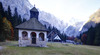 Mary Help chapel in Tamar is in shadow thrown by nearby mountains on early autumn morning, when temperatures fall under freezing level. mountaineering
