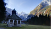 Mary Help chapel in Tamar is in shadow thrown by nearby mountains on early autumn morning, when temperatures fall under freezing level. mountaineering
