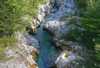 Emerald green Soca river is flowing through deep and narrow gorge near vas Soca, Slovenia.
