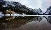 Frozen Toblachersee lake near Toblach, Italy, with Dolomites mountains and their reflection on unfrozen part of the lake on Saturday, 12th of March 2016.
