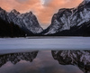 Frozen Toblachersee lake near Toblach, Italy, with Dolomites mountains and their reflection on unfrozen part of the lake on Saturday, 12th of March 2016.
