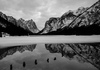 Frozen Toblachersee lake near Toblach, Italy, with Dolomites mountains and their reflection on unfrozen part of the lake on Saturday, 12th of March 2016.
