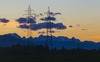 High voltage power lines on fields near Kranj, Slovenia, at the sunset with Julian Alps and Slovenia highest mountain Triglav in background.

