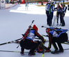 Franziska Preuss of Germany laying exhausted in finish with her teammates gathering together, and Italian relay celebrating their victory in the Women relay race of IBU Biathlon World Cup in Hochfilzen, Austria. Women relay race of IBU Biathlon World cup was held on Sunday, 13th of December 2015 in Hochfilzen, Austria.
