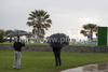 Fans with umbrellas watching the players tee off at the first hole of the first round of the European Tour Golf tournament, Open de Andalucia de Golf by Turkish Airlines, held at the Parador Malaga Golf Club, Malaga Spain.
