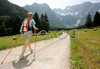 Nordic Walking in Jezersko with one of its valleys, Ravenska Kocna, under high mountains of Grintovec in early summer day. Grass is freshly cut, and high altitude makes summer day with hot temperatures bearable.
