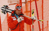 Finnish coach Mario Hani walking down the course with Tanja Poutiainen skis and poles after she crashed in first run of women giant slalom race of FIS Alpine skiing World Cup in Ofterschwang, Germany. Women giant slalom race of FIS Alpine skiing World Cup in Ofterschwang, Germany, was held on Saturday, 9th of March 2013.
